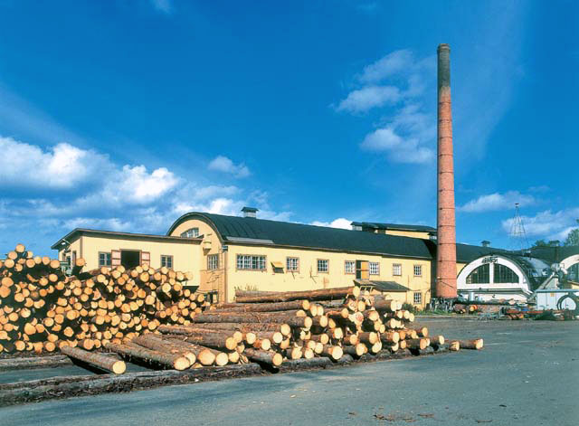 Iisveden metsä Oy:n saha. Taustalla puinen saharakennus, tiilinen savupiippu ja voima-asema. Soile Tirilä 2000